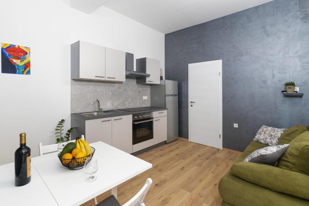 a kitchen and living room with a table and a couch at Stunning apartment in quiet street near center With free parking 4 floor in Rijeka
