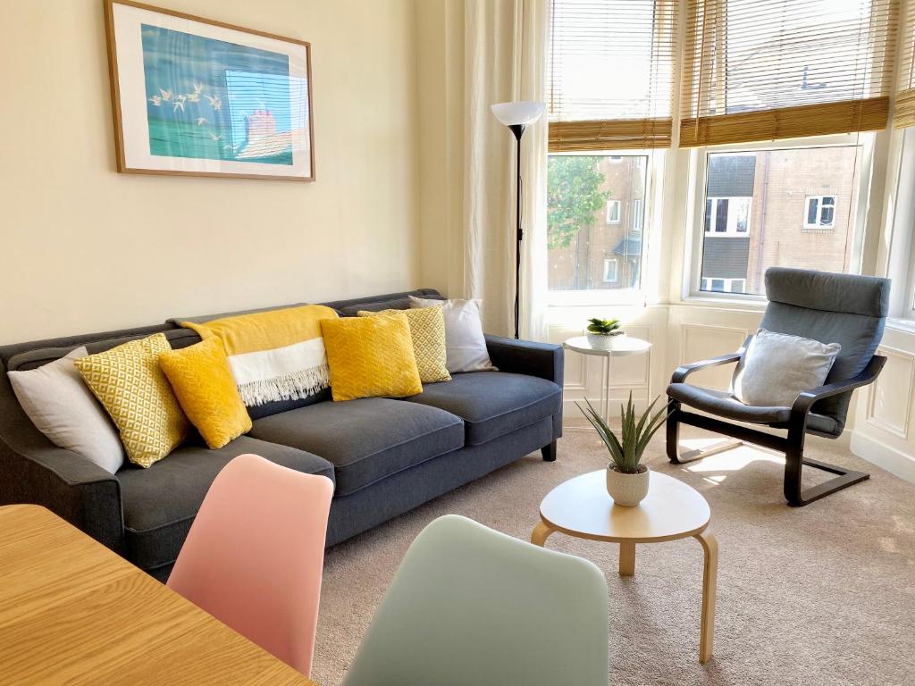 a living room with a couch and a chair at 8 Margaret Road, Whitley Bay in Whitley Bay
