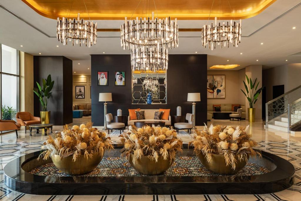 a lobby with chandeliers and a reception area at Four Points by Sheraton Production City, Dubai in Dubai