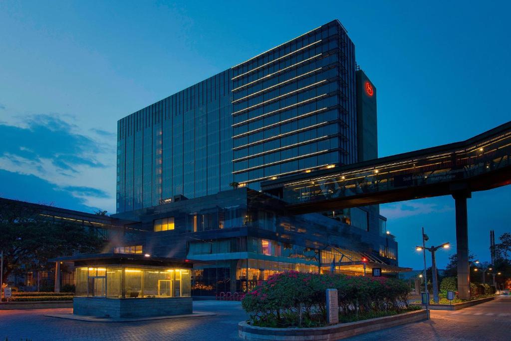 ein großes Gebäude mit seitlicher Uhr in der Unterkunft Sheraton Grand Bangalore Hotel at Brigade Gateway in Bangalore