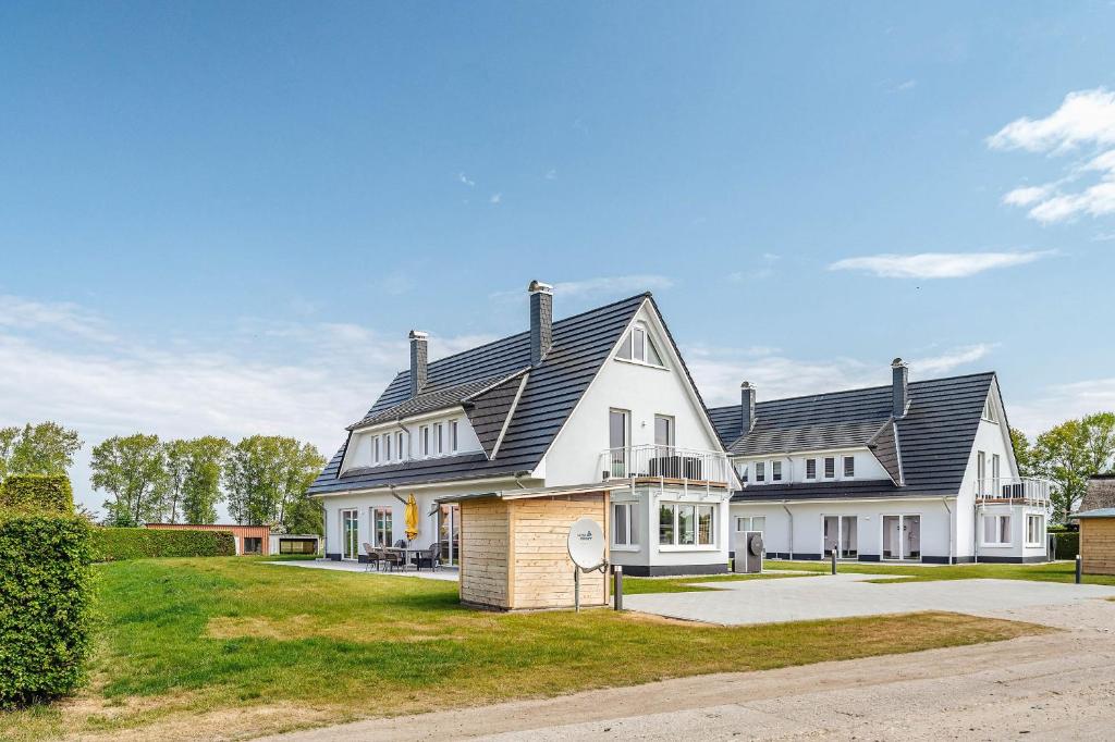 a large white house with a black roof at Zur Oie 27 in Bresewitz