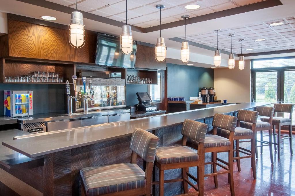 a bar with a row of bar stools in a restaurant at Four Points by Sheraton Columbus-Polaris in Columbus