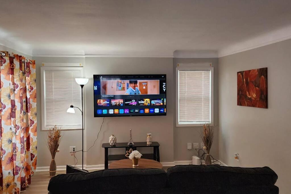 a living room with a couch and a flat screen tv at Beautiful 4 bedroom in Cleveland in Euclid
