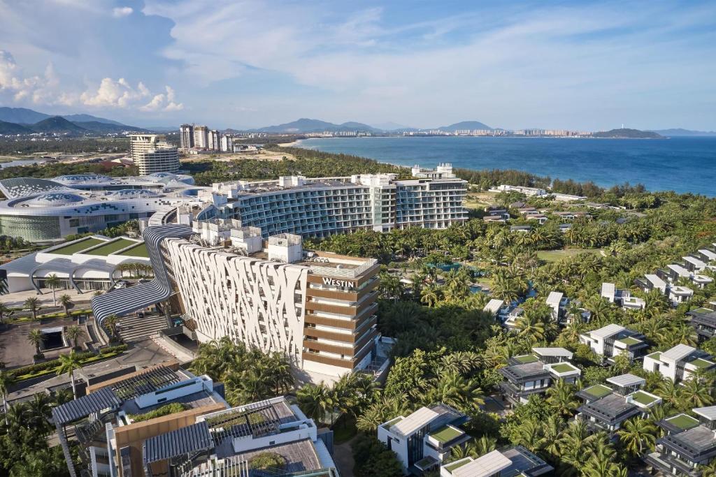 an aerial view of a city with buildings and the ocean at The Westin Sanya Haitang Bay Resort in Sanya