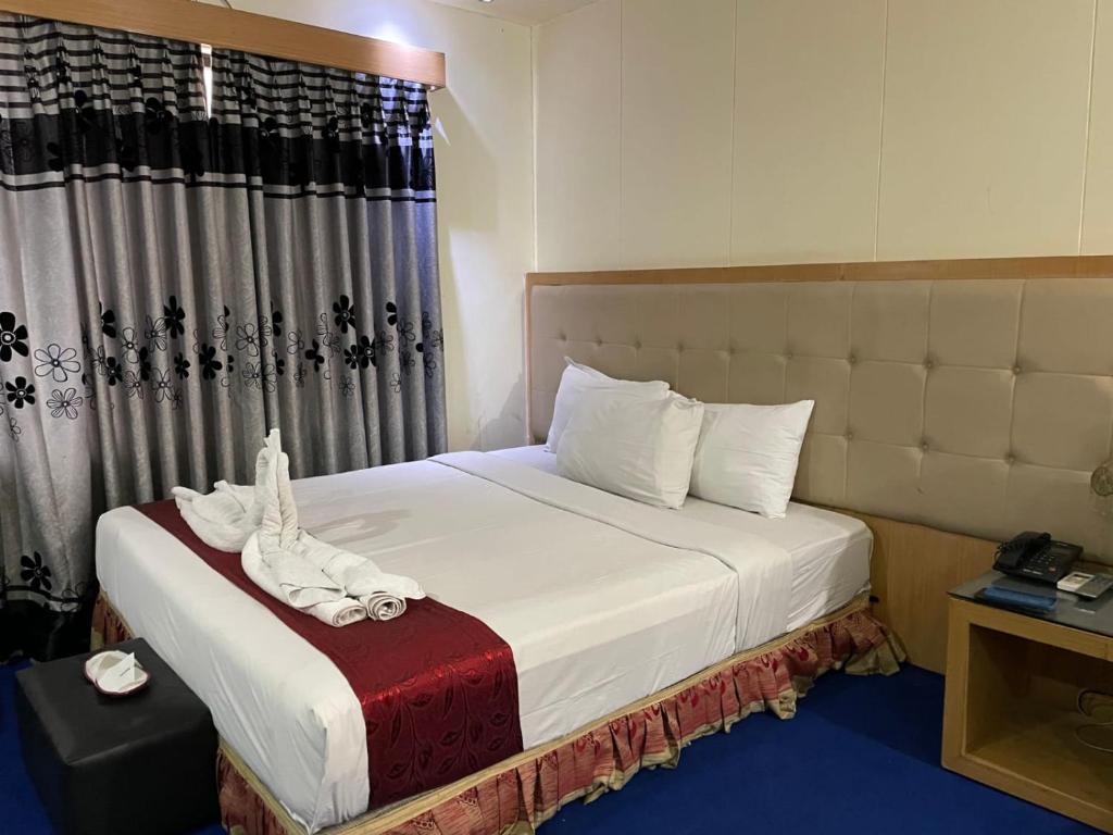 a hotel room with a bed with towels on it at Hotel Milina Uttara in Dhaka