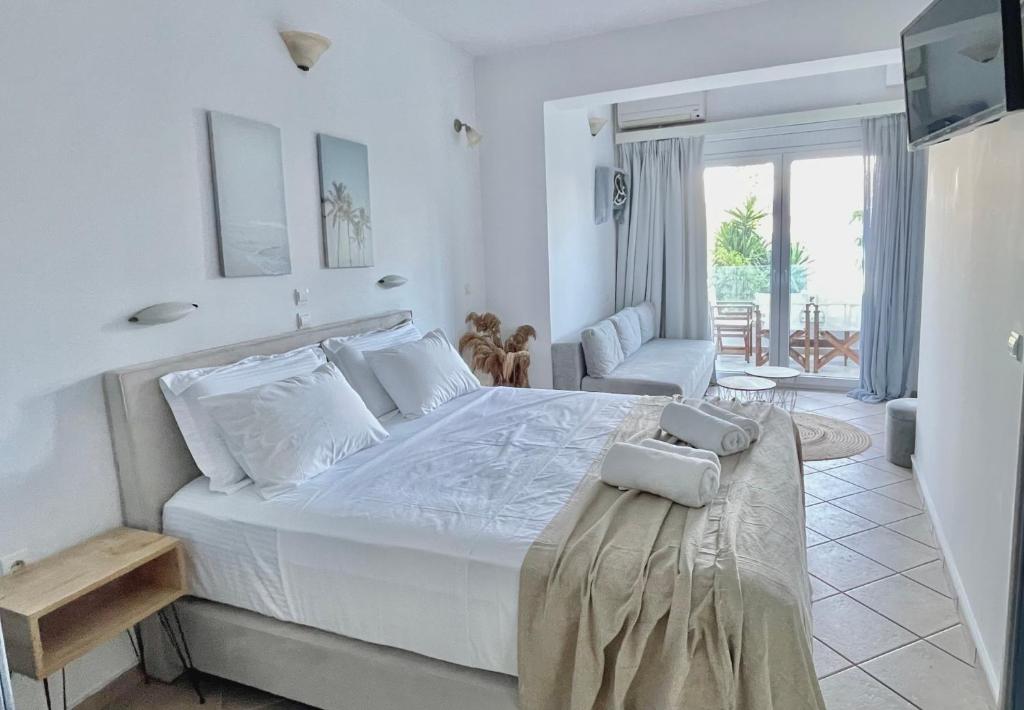 a white bedroom with a large bed and a couch at San Salvatore in Zakynthos