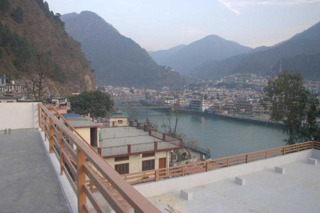 - une vue sur une rivière avec une ville et des montagnes dans l'établissement Panwar Palace, à Uttarkāshi