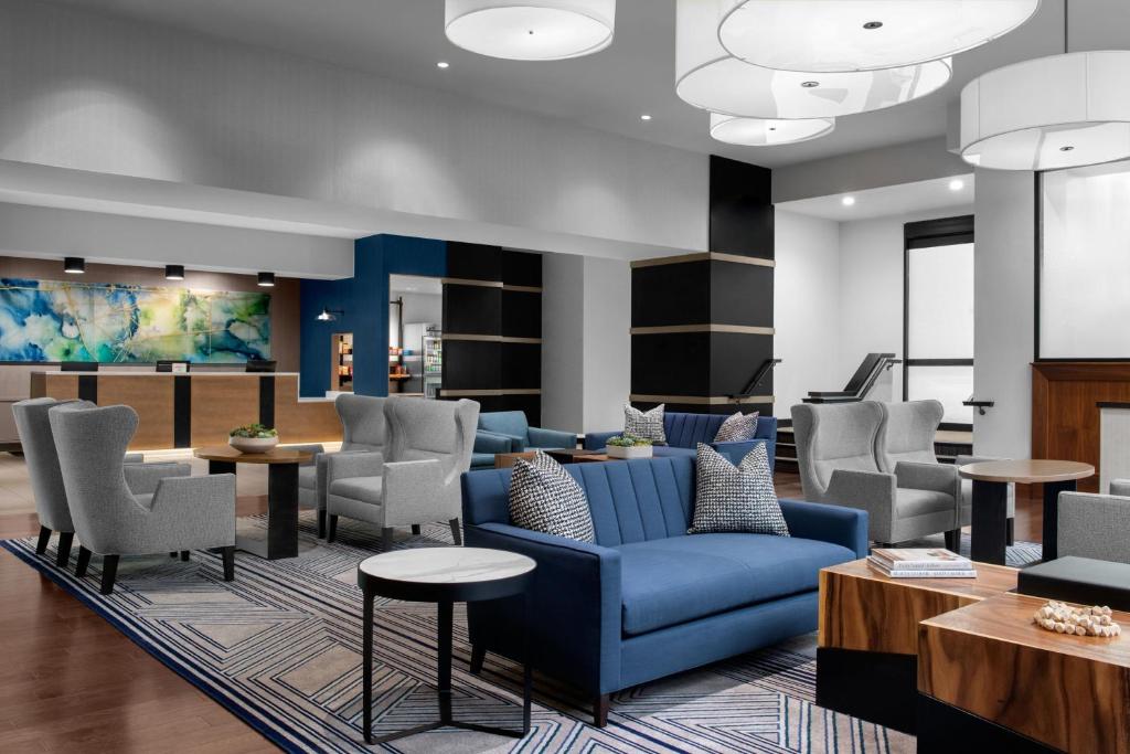 un vestíbulo con un sofá azul y sillas en Pleasanton Marriott en Pleasanton
