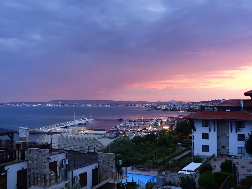 uma vista para um porto com uma marina ao anoitecer em Dolce Vita Blue Boho, Premium Apartment with seaview em Sveti Vlas