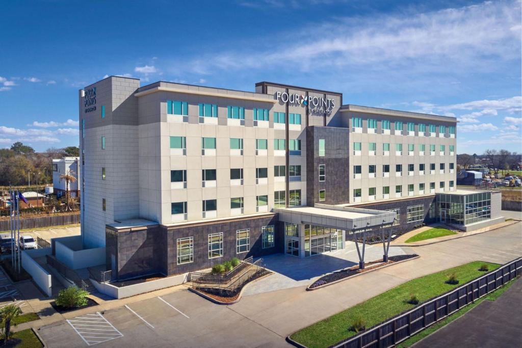 a large building with a parking lot in front of it at Four Points by Sheraton Houston Intercontinental Airport in Houston