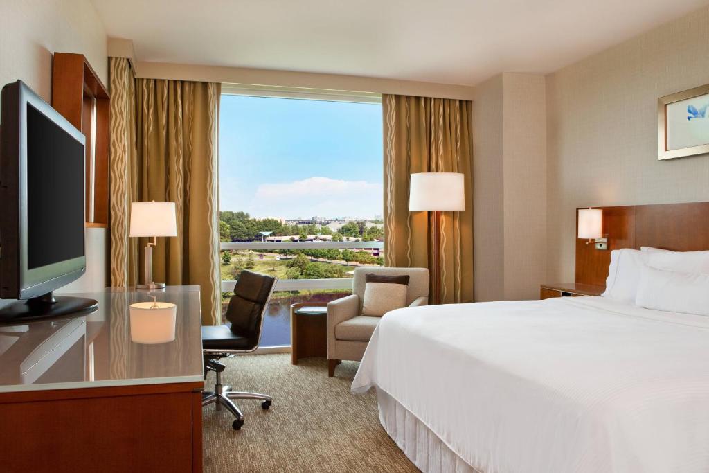 a hotel room with a bed and a large window at The Westin Washington Dulles Airport in Herndon