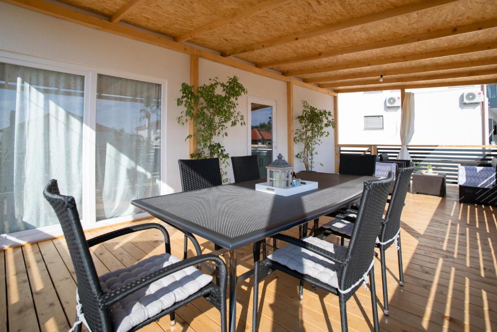 een eetkamer met een tafel en stoelen op een balkon bij Mobile Home Lana in Murter