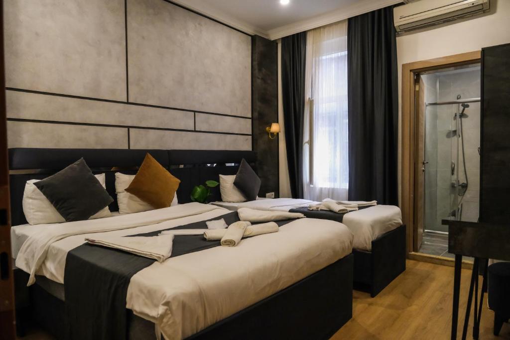 2 Betten in einem Hotelzimmer mit Handtüchern darauf in der Unterkunft La Pazza Suites in Istanbul