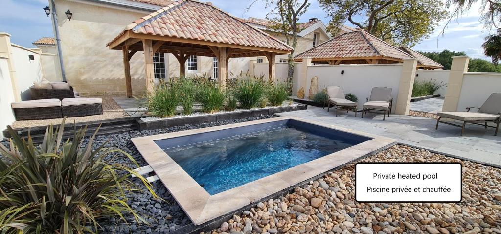 uma piscina num quintal com um gazebo em Dom Peyreton Prestige cottages set in a charming wine property em Villegouge