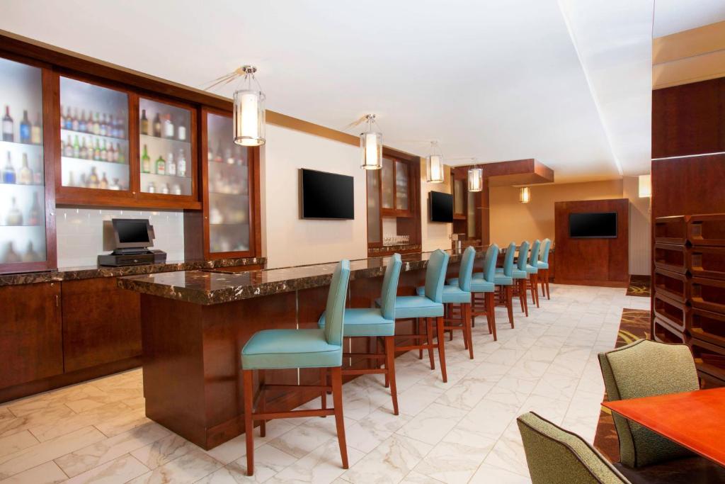 a bar with a row of chairs in a restaurant at Sheraton Pittsburgh Airport Hotel in Coraopolis