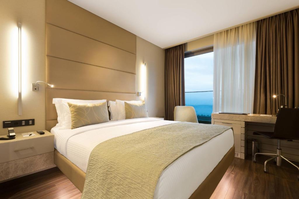 イスタンブールにあるマリオット ACホテル イスタンブール マチカの大きなベッドと窓が備わるホテルルームです。