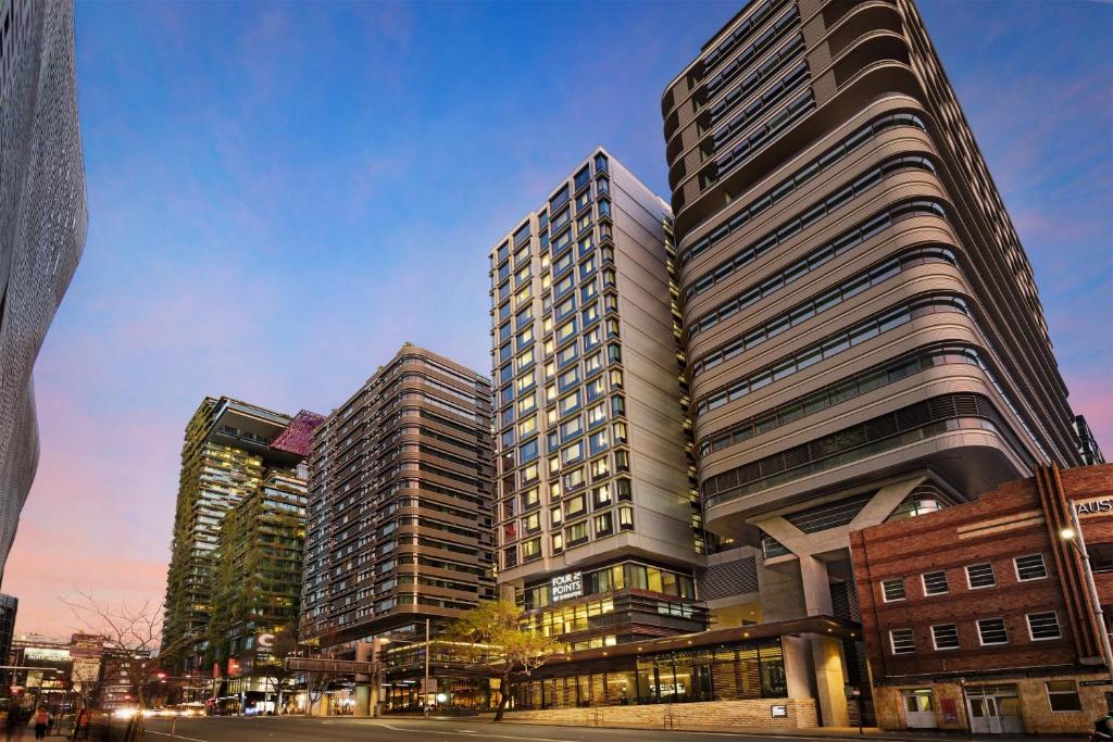 雪梨的住宿－悉尼中央公園福朋喜來登酒店，两座高楼,位于一个街道上
