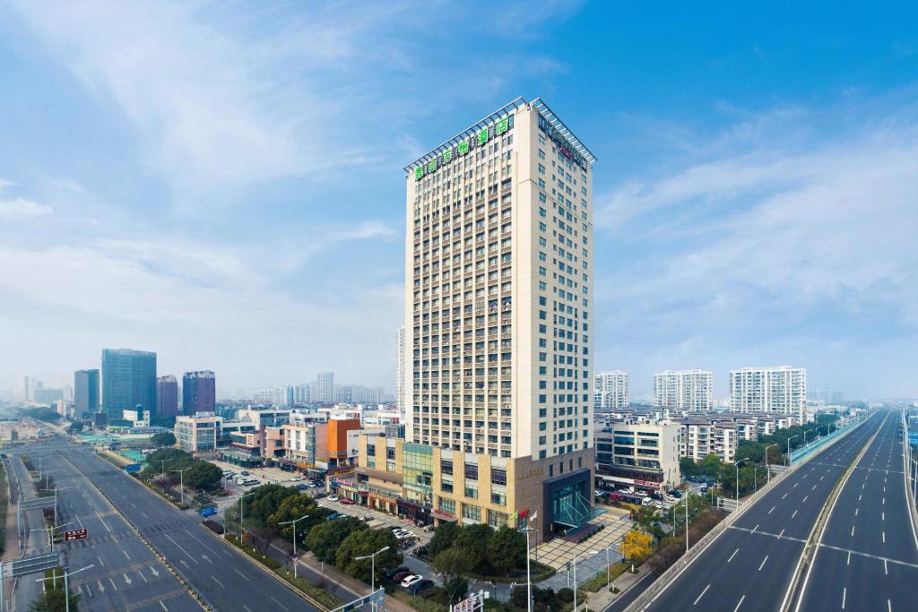 um alto edifício branco no meio de uma cidade em Courtyard by Marriott Kunshan em Kunshan