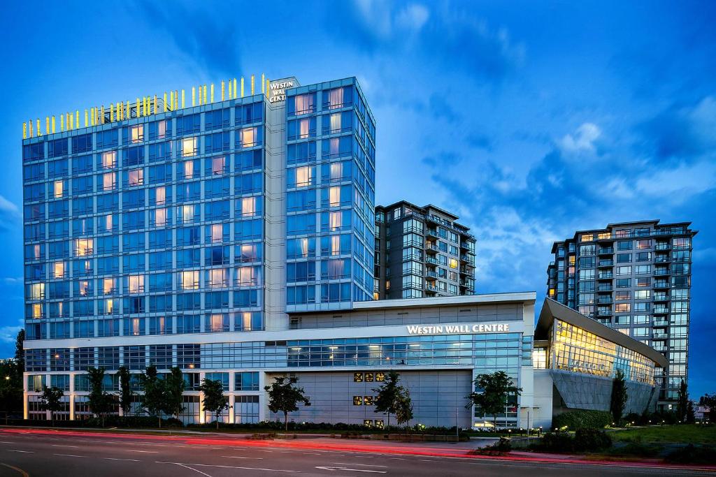a large glass building with two tall buildings at The Westin Wall Centre, Vancouver Airport in Richmond