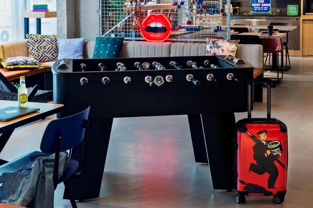 a large black table with a suitcase in a room at Moxy Paris Bastille in Paris
