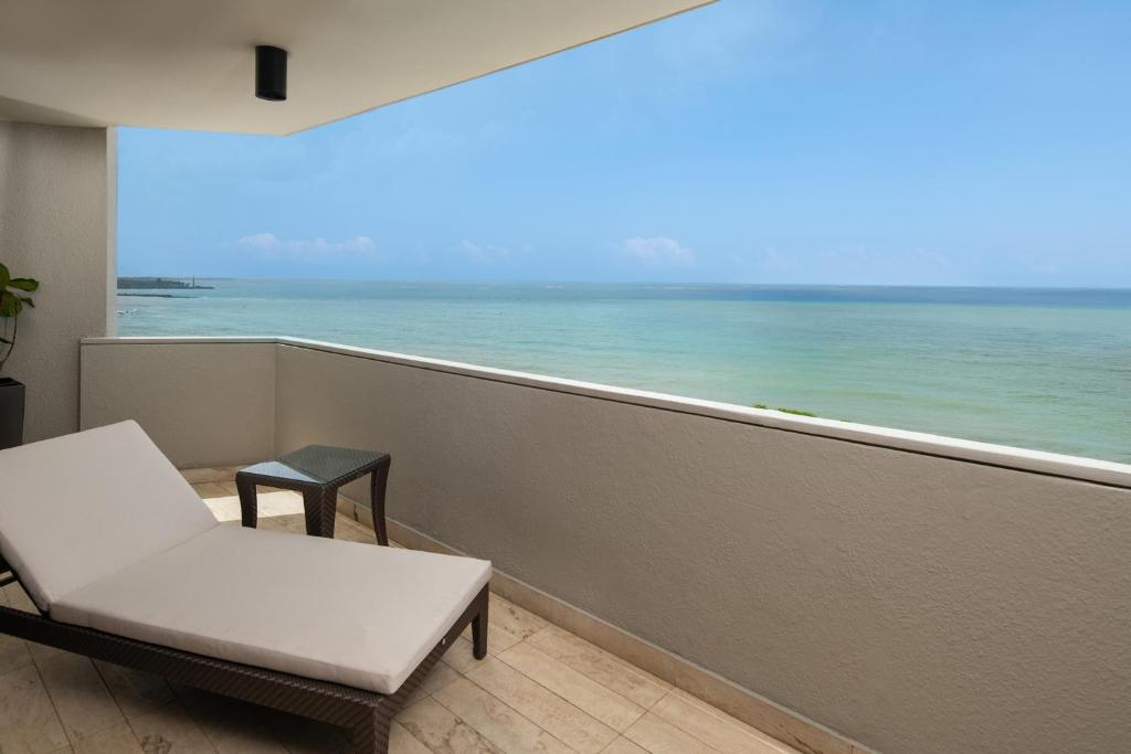 a balcony with a white chair and a view of the ocean at Sheraton Santo Domingo in Santo Domingo