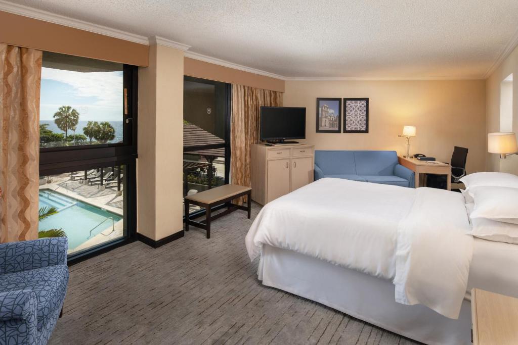 a hotel room with a large bed and a balcony at Sheraton Santo Domingo in Santo Domingo