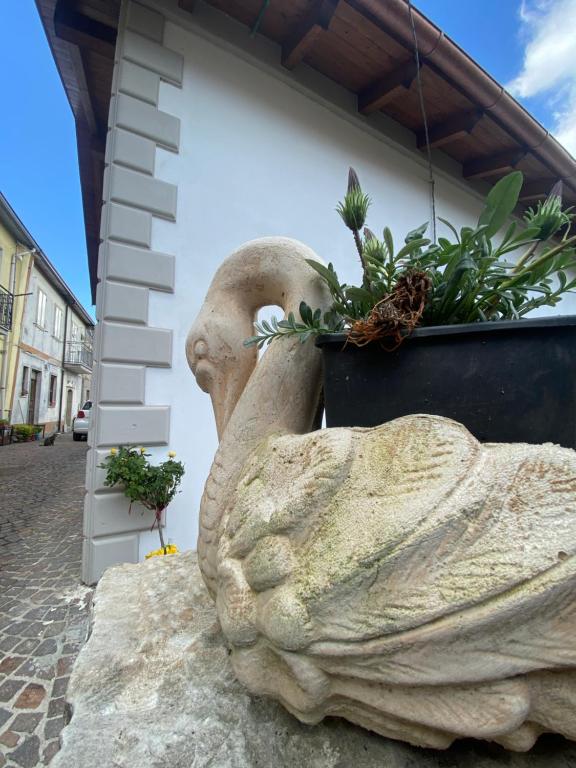 una estatua de un hombre sosteniendo una maceta en La Perla Del Borgo en Montefalcone di Val Fortore