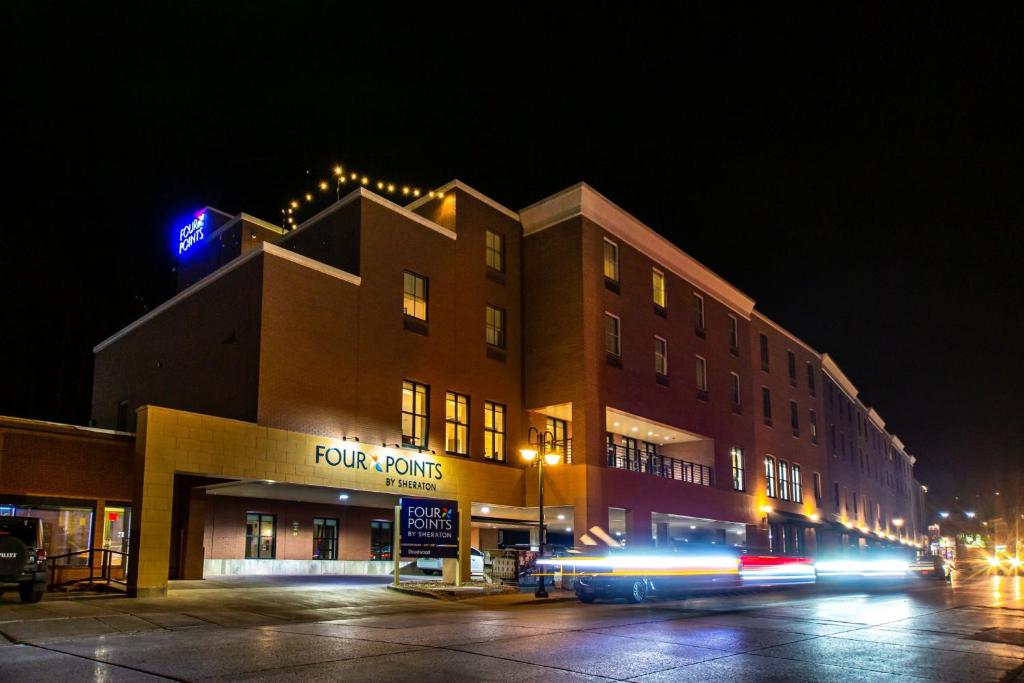 a bus driving past a building at night at Four Points by Sheraton Deadwood in Deadwood