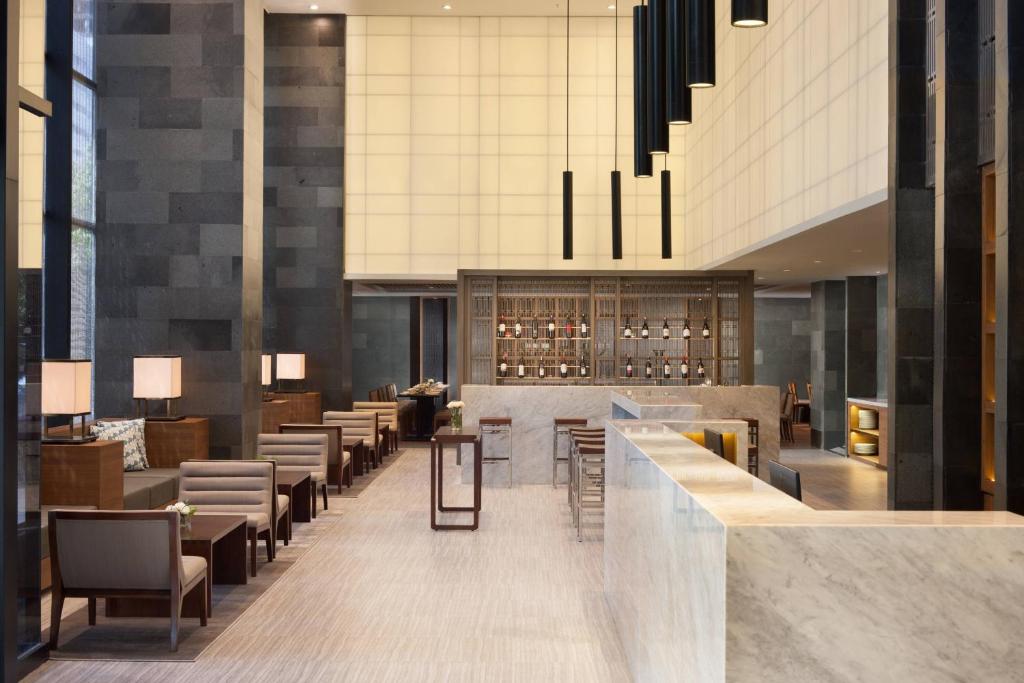 a lobby of a hotel with a bar and chairs at Four Points by Sheraton Jakarta Thamrin in Jakarta