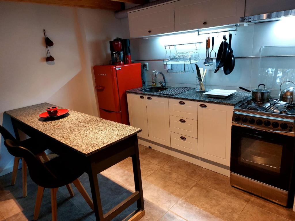 cocina con mesa y nevera roja en Hermoso Apto equipado a nuevo !, en Montevideo