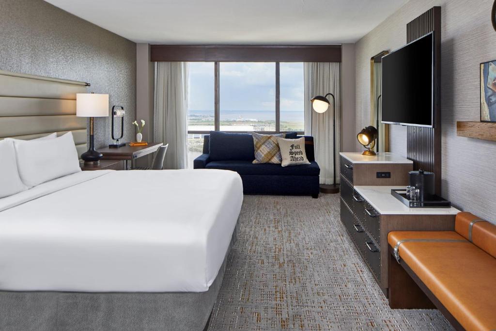 a hotel room with a large bed and a couch at Renaissance Mobile Riverview Plaza Hotel in Mobile