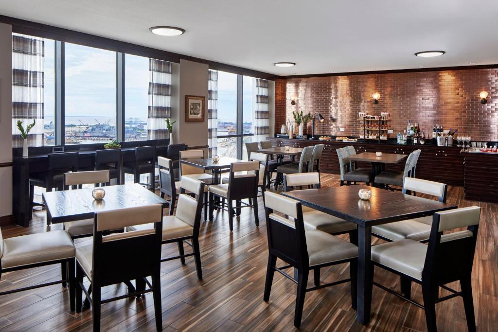 a restaurant with tables and chairs and a bar at Renaissance Mobile Riverview Plaza Hotel in Mobile
