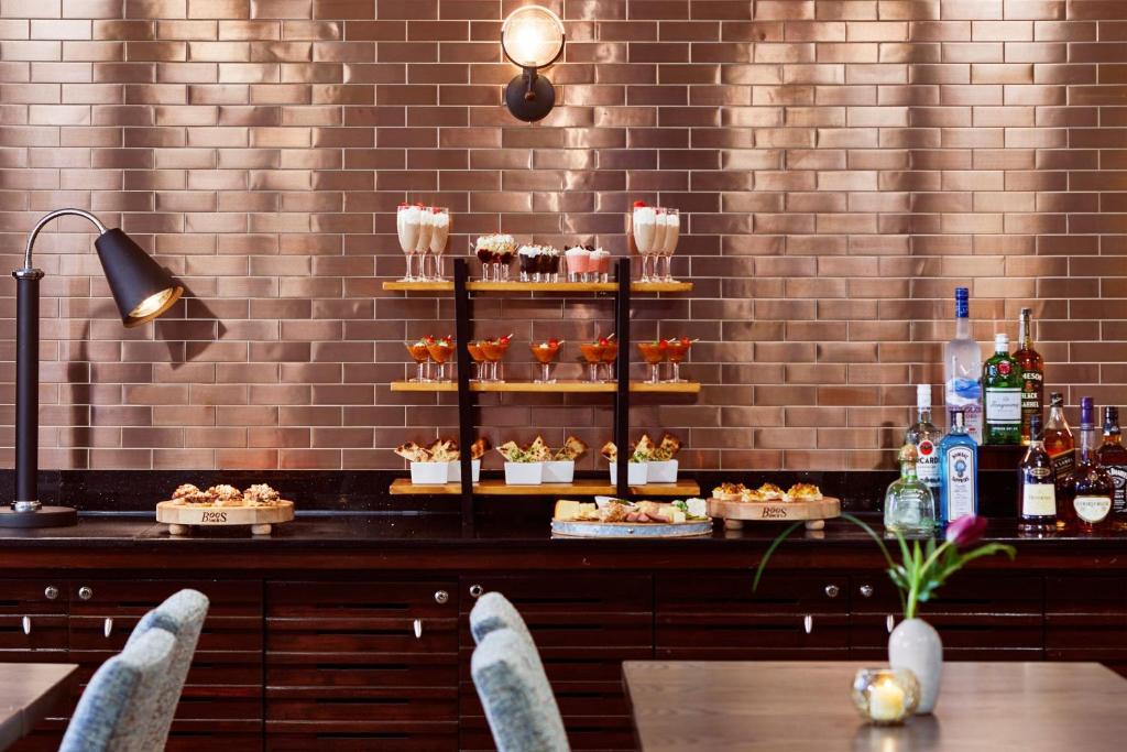 a restaurant with a display of food on a counter at Renaissance Mobile Riverview Plaza Hotel in Mobile