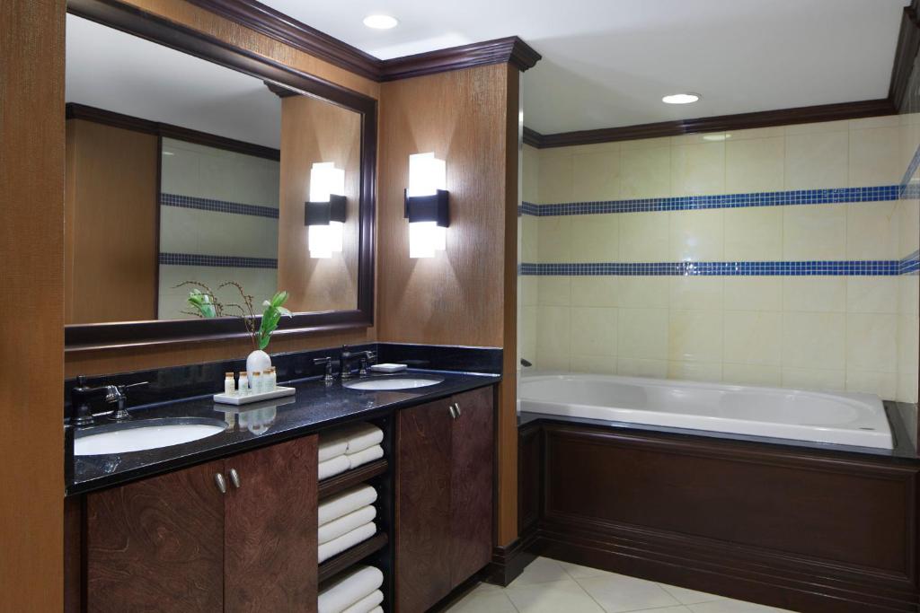 a bathroom with two sinks and a bath tub at Renaissance Mobile Riverview Plaza Hotel in Mobile