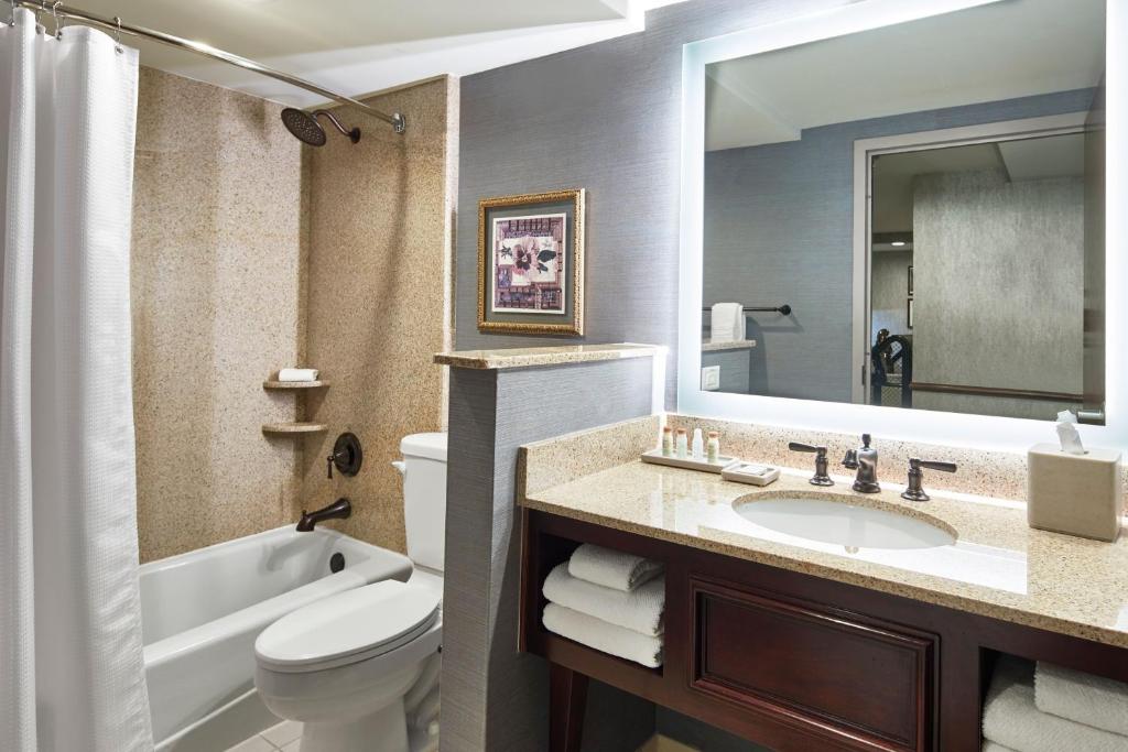 a bathroom with a sink and a tub and a toilet at Renaissance Mobile Riverview Plaza Hotel in Mobile