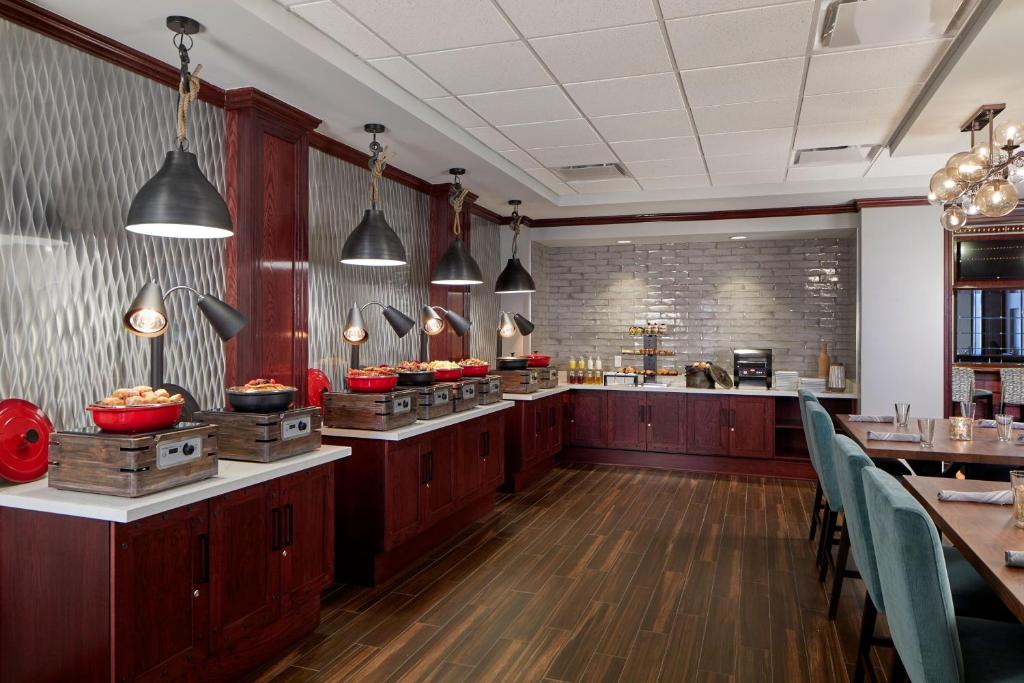 a restaurant with a kitchen with tables and chairs at Renaissance Mobile Riverview Plaza Hotel in Mobile