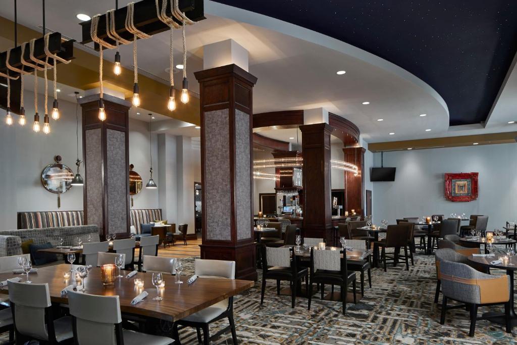 a restaurant with tables and chairs in a room at Renaissance Mobile Riverview Plaza Hotel in Mobile