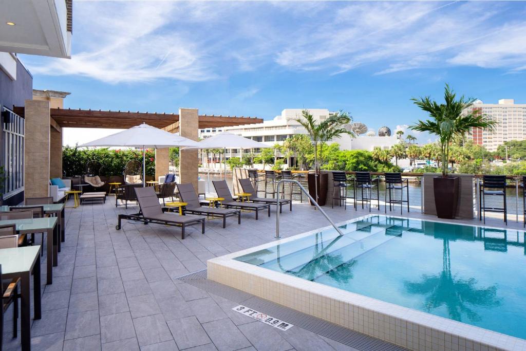 坦帕的住宿－坦帕市區雅樂軒酒店，酒店庭院设有游泳池和桌椅