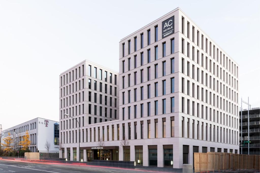 dos altos edificios blancos en una calle de la ciudad en AC Hotel by Marriott Wuerzburg en Würzburg