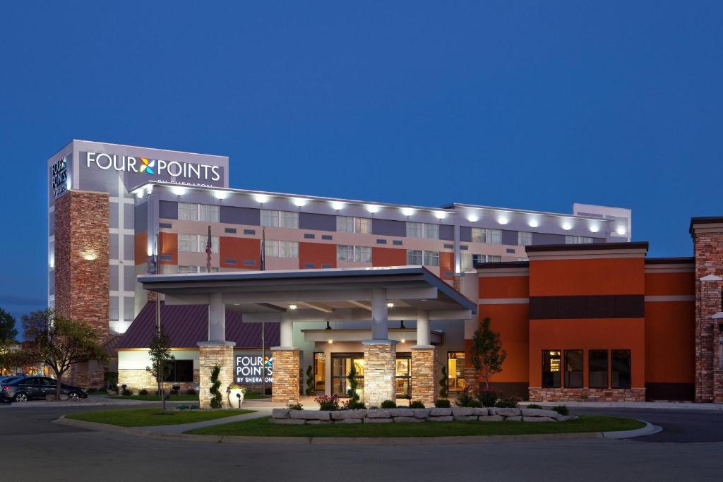 un edificio de hotel con un letrero de cuatro puntos en él en Four Points By Sheraton - Saginaw, en Saginaw