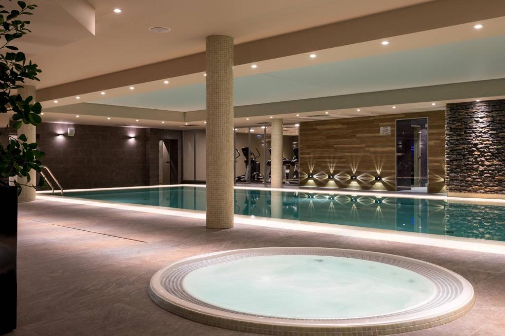 a swimming pool in a hotel with a swimming tub at AC Hotel by Marriott Wroclaw in Wrocław