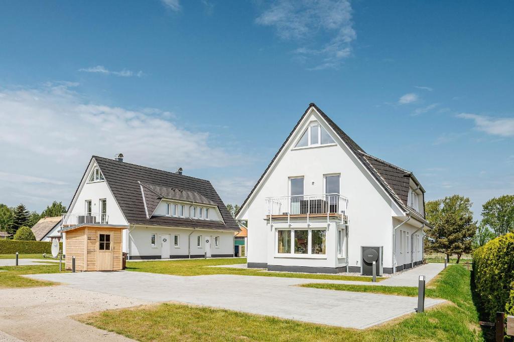 a white house with a black roof at Zur Oie 27b in Bresewitz