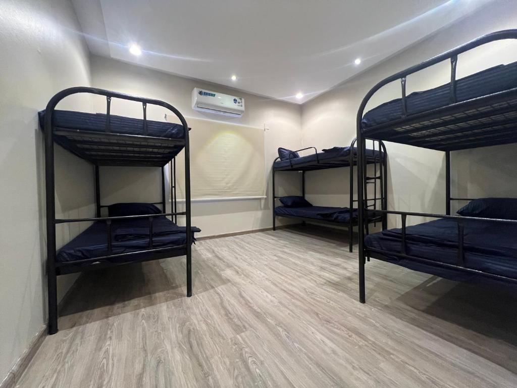 a room with three bunk beds in it at Hakimdom Hostel in Riyadh