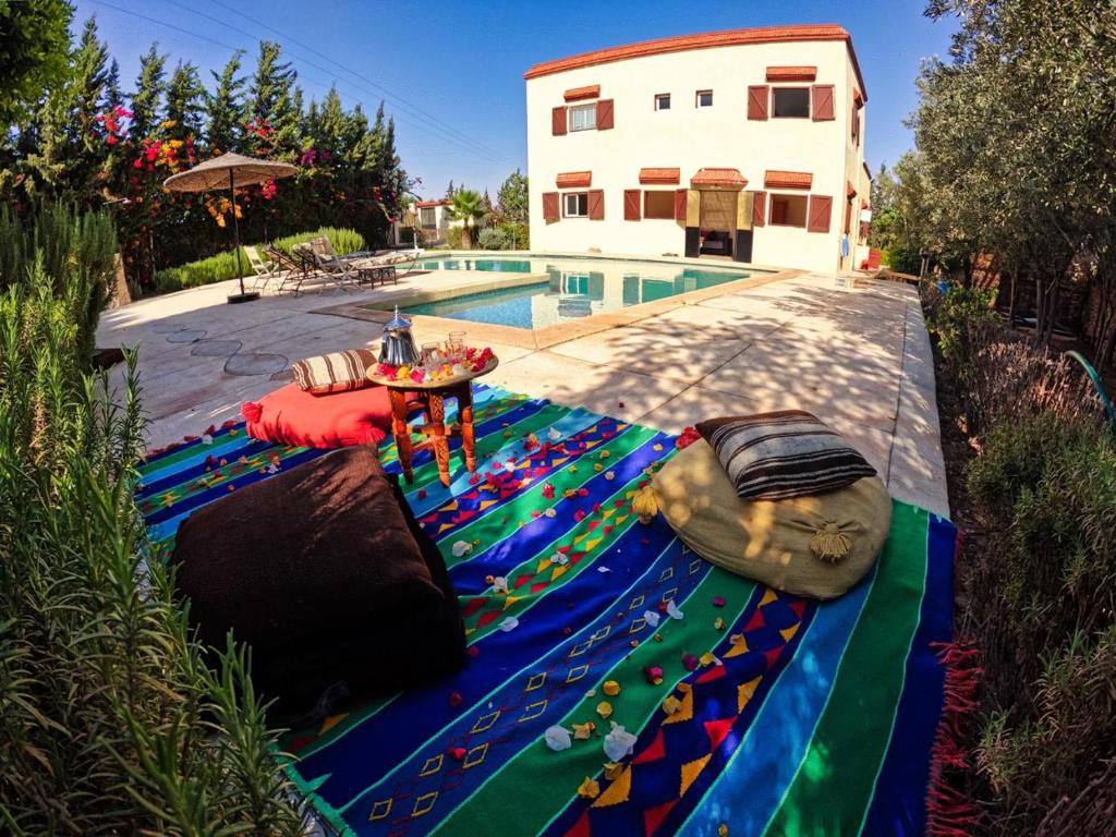 a pool with a colorful blanket next to a house at Villa Essaouira Mogador in Ounara