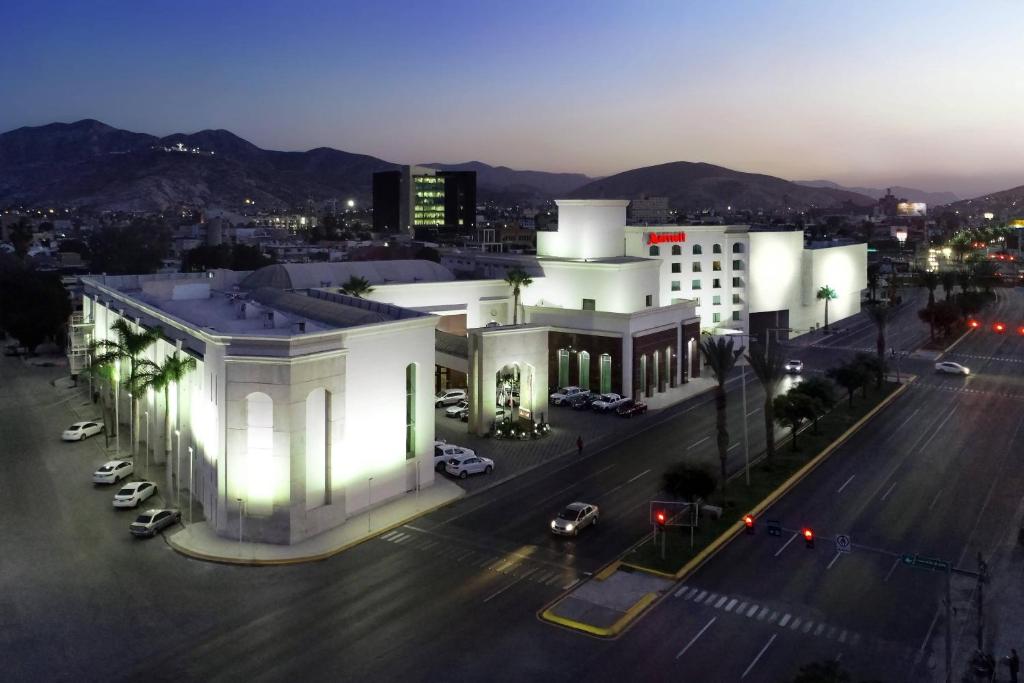 a large white building in a city at night at Marriott Torreon Hotel in Torreón