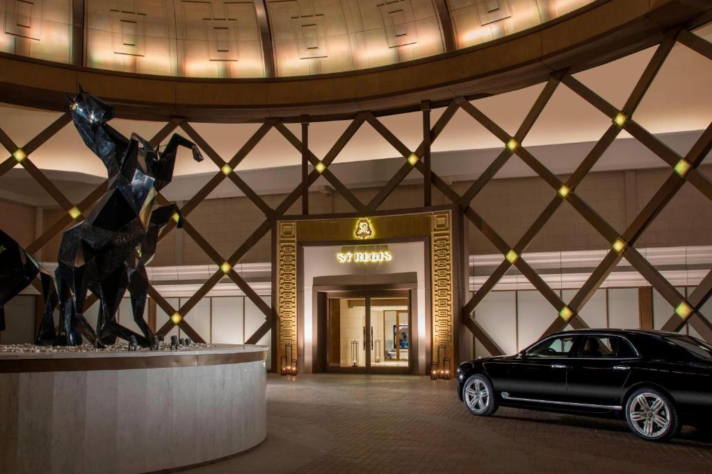 a car parked in front of a building with a statue at The St. Regis Astana in Astana