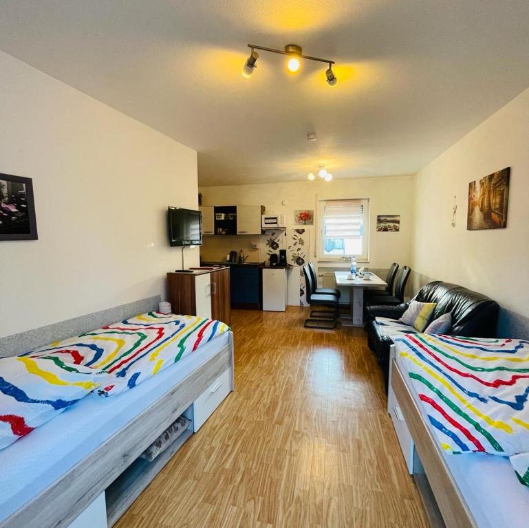 a room with two beds and a living room at Ferienwohnung in Binger Stadtmitte mit Balkon in Bingen am Rhein