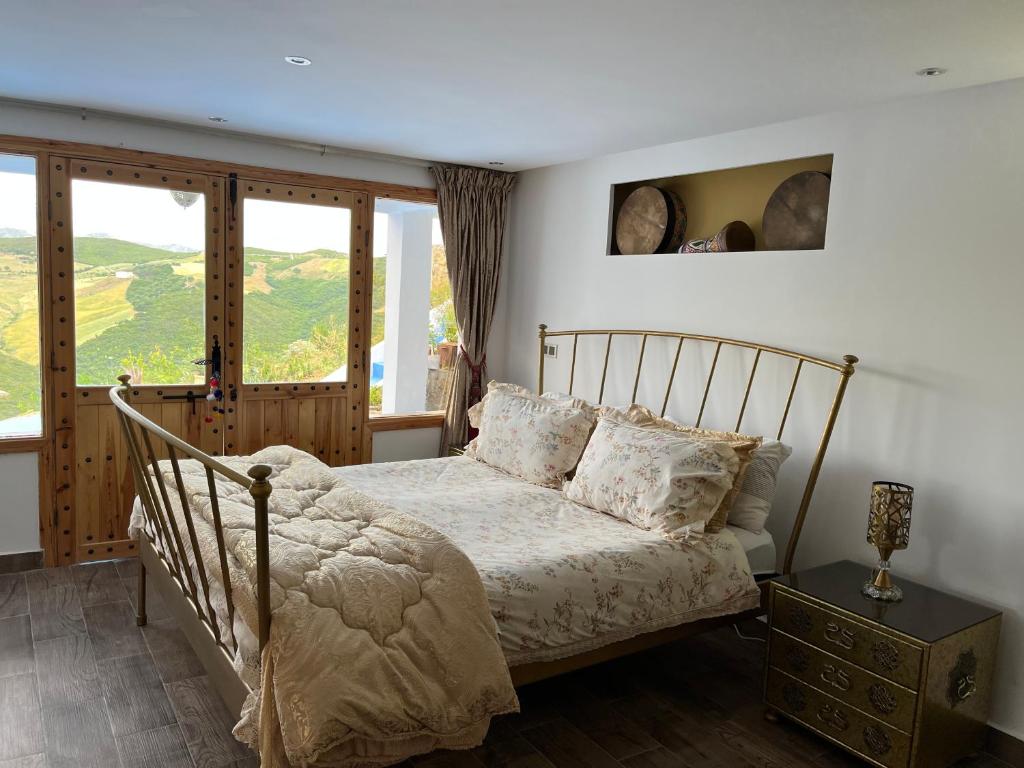 Schlafzimmer mit einem Bett mit einem Holzrahmen und Fenstern in der Unterkunft Sanae house 