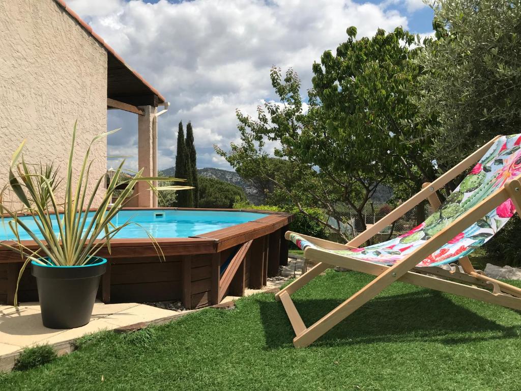 krzesło i basen na dziedzińcu w obiekcie Villa Cléa, belle propriété provençale, jardin, piscine, au calme w mieście Carnoux-en-Provence