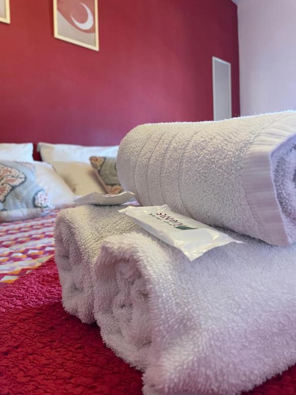 una pila de toallas sentadas encima de una cama en POSADA DEL CENTRO en Villa General Belgrano